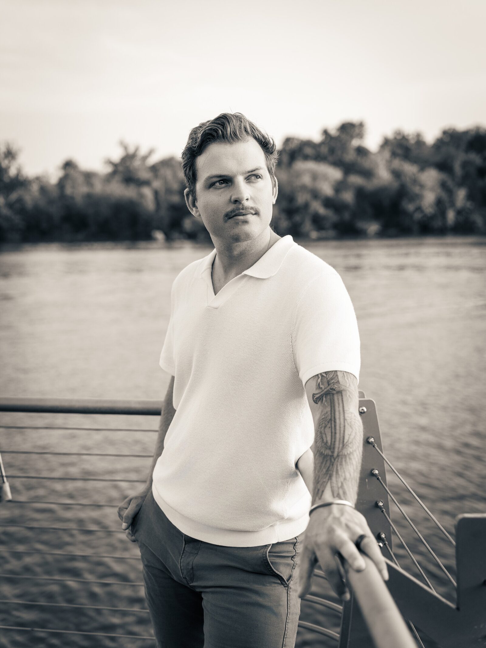 Black-and-white waterfront portrait of a man looking into the distance in Washington, D.C.