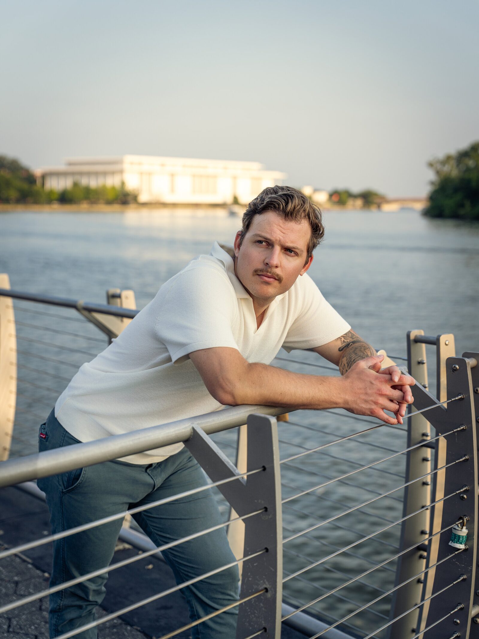 Editorial portrait of a man leaning on a waterfront railing in Washington, D.C.